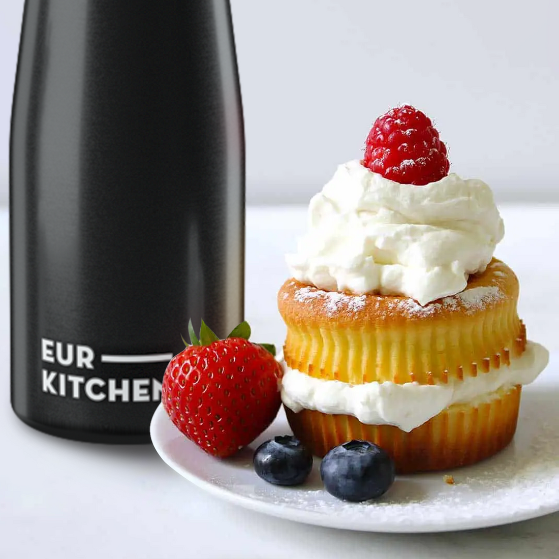 EurKitchen Whipped Cream Dispenser next to cupcake with berries topped with whipped cream