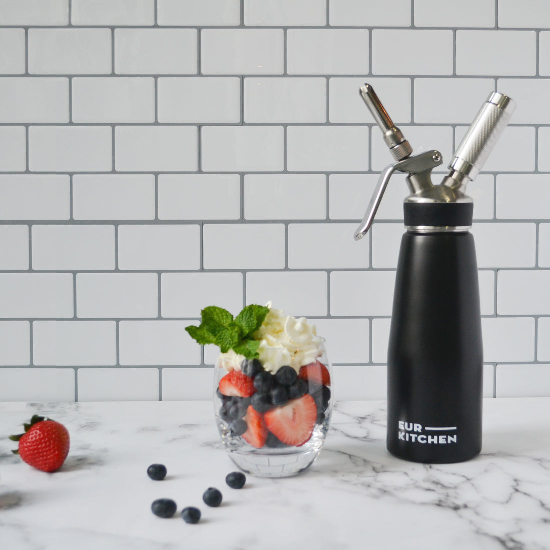 EurKitchen Whipped Cream Dispenser next to a pot with berries topped with whipped cream